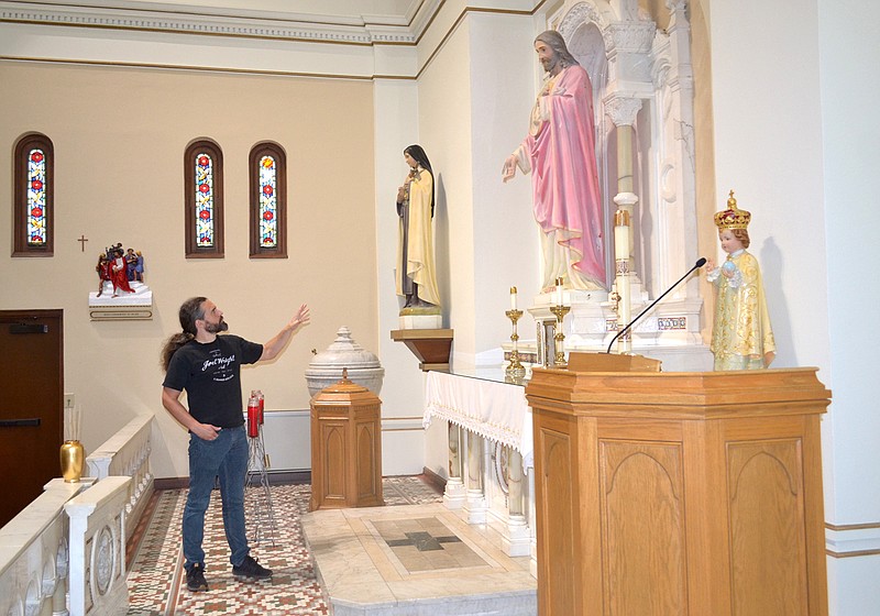 Local artist Joel Wright, tasked with reconditioning the statues and stations of the cross at St. Edward Catholic Church in downtown Texarkana, describes his plans for the color scheme of the statue of Jesus. "I've always wanted to paint Jesus but was unsure of the skin color. I did some research and I think I've done well." (Photo by Kate Stow)