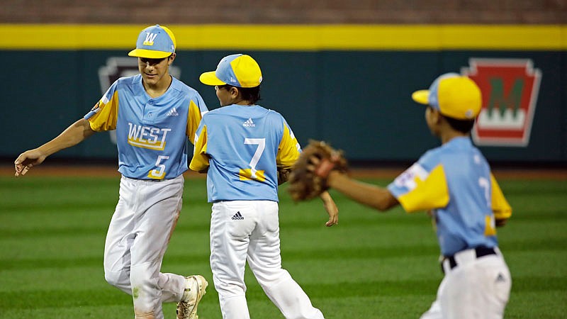 Hawaii center fielder Kaleb Mathias (5) and Isaac Imamura (7) celebrate their 12-9 win Wednesday against South Riding, Va. during the Little League World Series in South Williamsport, Pa.