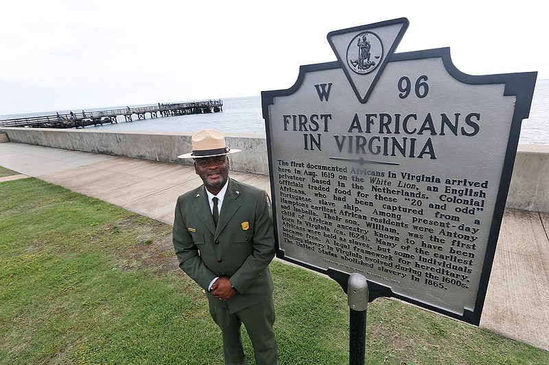 Terry E. Brown, Superintendent of the Fort Monroe National Monument poses next to a historical marker that signifies the spot of the first landing of Africans in America 400 years ago at Fort Monroe in Hampton, Va., Thursday, Aug. 15, 2019. (AP Photo/Steve Helber)
