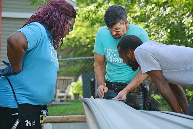 Construction manager Shane Spalding shows Annette Cunningham and Jamal Resonno how to measure scaffolding Saturday as crew members work on a River City Habitat for Humanity home along East Dunklin Street. 