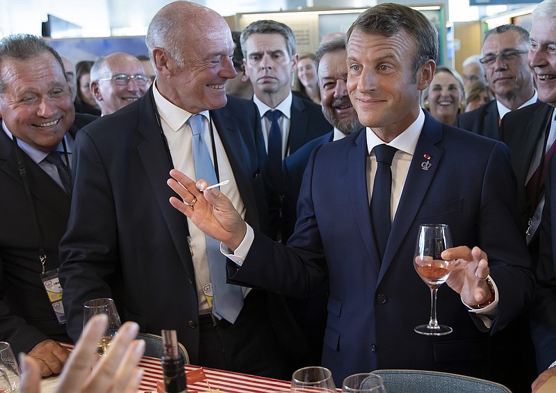 French President Emmanuel Macron, right right, flanked by President of the Nouvelle-Aquitaine region Alain Rousset, center, samples local produce and wine, as he tours the exhibition hall above the international press center on the opening day of the G7 summit, in Anglet, southwestern France, Saturday Aug.24, 2019. U.S. President Donald Trump and the six other leaders of the Group of Seven nations will begin meeting Saturday for three days in the southwestern French resort town of Biarritz. France holds the 2019 presidency of the G-7, which also includes Britain, Canada, Germany, Italy and Japan. Biarritz. (Ian Langsdon, Pool via AP)