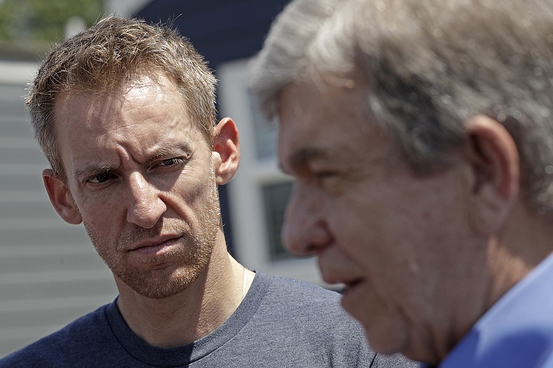 FILE--In this July 26, 2019, file photo, Jason Kander, left, listens while Missouri Republican Sen. Roy Blunt talks to the media after touring the Veteran's Community Project in Kansas City, Mo. Kander's job running a nonprofit for homeless veterans has made the Kansas City site a campaign stop for Democratic presidential hopefuls. The former Missouri secretary of state was considered a strong candidate to be mayor of Kansas City. Then he dropped out of the race to get treatment for the post-traumatic stress disorder he'd struggled with since leaving the Army 11 years earlier. (AP Photo/Charlie Riedel, File)