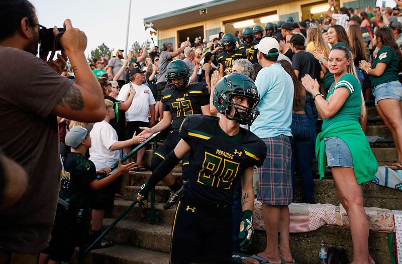 Paradise wide receiver Del Smith (80) and his teammates run down the steps of the stands during the opening ceremony of their high school football game against Williams on Friday in Paradise, Calif. This is the first game for the school since a wildfire in November killed multiple people and destroyed nearly 19,000 buildings, including the homes of most of the Paradise players.