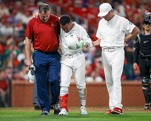 Kolten Wong is helped off the field by Cardinals manager Mike Shildt and a trainer after fouling a ball off of his foot during the seventh inning of Saturday night's game against the Rockies at Busch Stadium.
