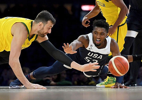 Andrew Bogut of Australia (left) and Donovan Mitchell of the United States compete for a loose ball during Saturday's exhibition game in Melbourne.