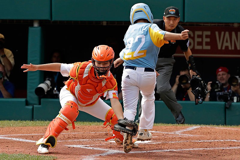 River Ridge, La. catcher Egan Prather tags the leg of Wailuku, Hawaii's Bransyn Hong for the out at home plate in the first inning of the United State championship game Saturday at the Little League World Series in South Williamsport, Pa.
