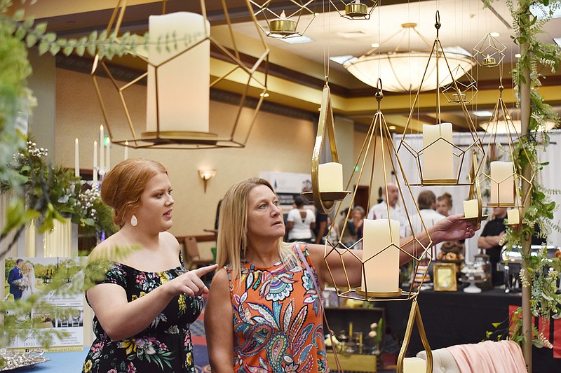 Bride-to-be Megan VanderFeltz, left, and her mother, Vicki Bremmerkamp, look at geometric votive candle holders at Sunday's Fall Bridal Spectacular 2019 at Capitol Plaza Hotel. This year's fall event is set for noon to 3 p.m. Sunday. 