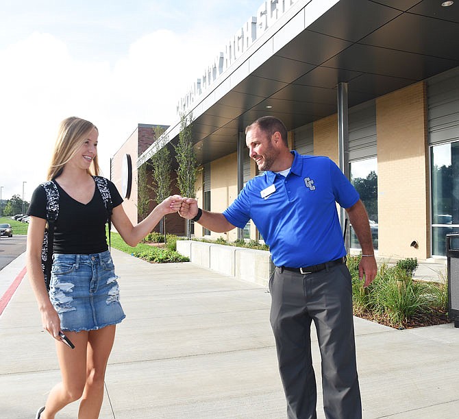 Freshman Olivia Sloan is greeted with a fist bump by Capital City High School Principal Ben Meldrum on Tuesday as she prepared to enter the building for the first day of classes. CCHS opened its doors to freshmen and sophomores this year with grades 9-12 starting in 2021.