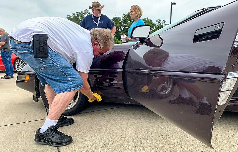 Robert Bush wipes down his 1994 Corvette on Tuesday at the Arkansas Welcome Center near Mandeville, Ark., before leaving for Little Rock. Hundreds of Corvette enthusiasts will converge on the National Corvette Museum in Bowling Green, Ky., to celebrate the museum's 25th anniversary.