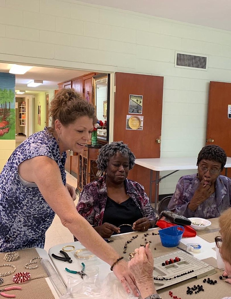 Melissa Sawyer helps seniors create jewelry during a recent class at Collins Senior Center.
