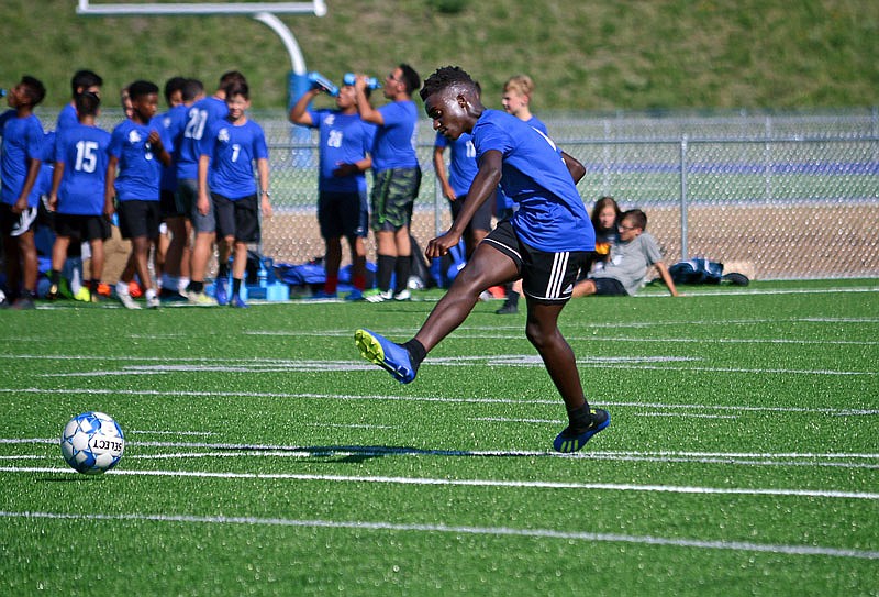 Emmanual Borde-Koufie kicks a ball towards the goal Wednesday during practice at Capital City High School.