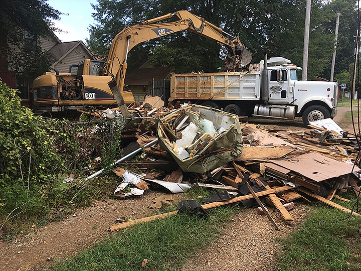 A garage apartment behind a house on 2520 Magnolia St. in Texarkana was flattened Wednesday, Aug. 28, 2019. Demolition equipment began pulling the building down about 8 a.m. Wednesday as Texas-side police blocked the alley for safety. A truck and backhoe were loading and hauling off the rubble at about 1:30 p.m., as seen here. The building was located at the back alley and, because the property on the other side of the alley is also vacant, the tear-down was visible to passing motorists on State Line Avenue near the 26th Street intersection. (Staff photo by Les Minor)