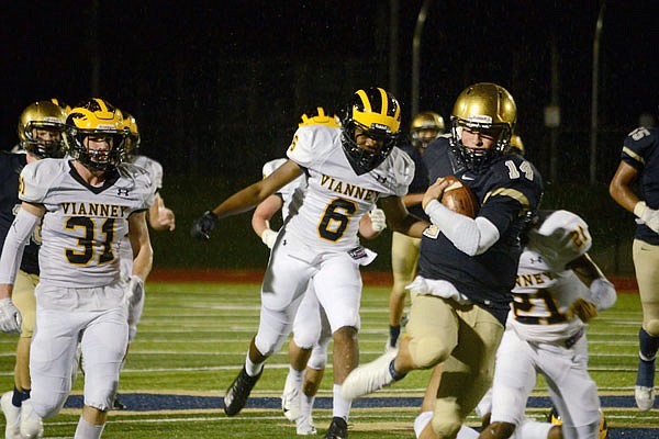 Helias quarterback Jacob Weaver runs past Vianney defenders during a game last season at the Crusader Athletic Complex. Weaver, a junior, combined for more than 2,700 yards of offense for the Crusaders last season.