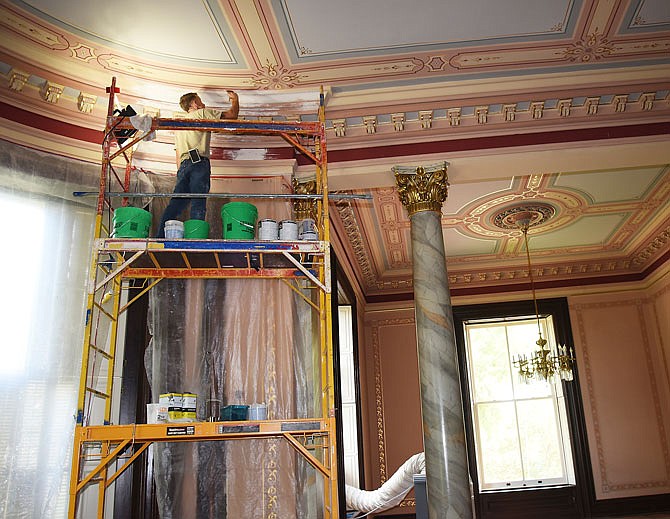Artist craftsman Brad Bruce repaints near the ceiling in a first-floor dining room at the Missouri Governor's Mansion. Bruce, who works for Kansas City-based Retropros, was one of several workers seen on the job as Sherry Kempf of Facilities Management led a tour of the mansion Thursday and described the work being done at the home.