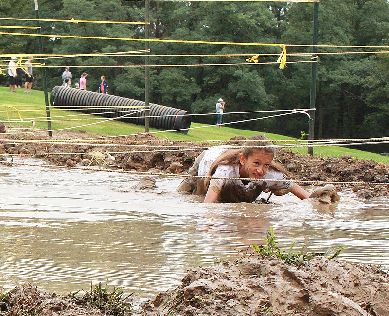 Jilian Moseley, 9, goes through the mud crawl, one of the many obstacles Saturday during the Catch Me If You Can Fun Run and Obstacle Course. Jilian's mom, Crystal Moseley, also took her turn during the Prison Break race at Ellis-Porter Riverside Park.