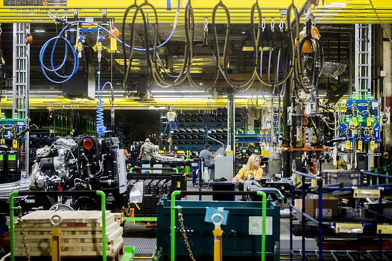 FILE - In this June 12, 2019, file photo General Motors employees work on the chassis line as they build the frame, power train and suspension onto the truck's body at the Flint Assembly Plant in Flint, Mich. On Tuesday, Sept. 3, the Institute for Supply Management, a trade group of purchasing managers, issues its index of manufacturing activity for August. (Jake May/The Flint Journal via AP, File)