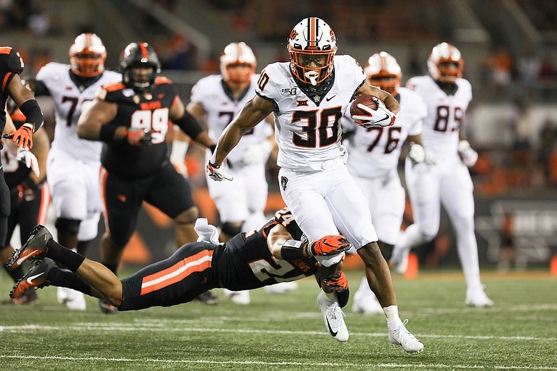 Oklahoma State running back Chuba Hubbard (30) is brought down by Oregon State defensive back David Morris (24) during the first half of an NCAA college football game in Corvallis, Ore., Friday, Aug. 30, 2019. (AP Photo/Amanda Loman)