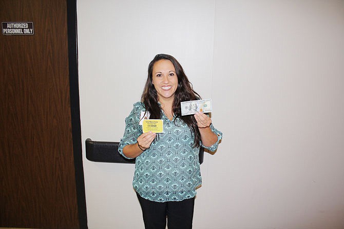 Andrea Bedrosian, Fulton Medical Center's director of marketing, holds the golden certificate and the prize of $100 at the medical center. For 12 weeks, there will be a golden certificate hidden around Fulton, and clues will be given from the medical center's Facebook page.