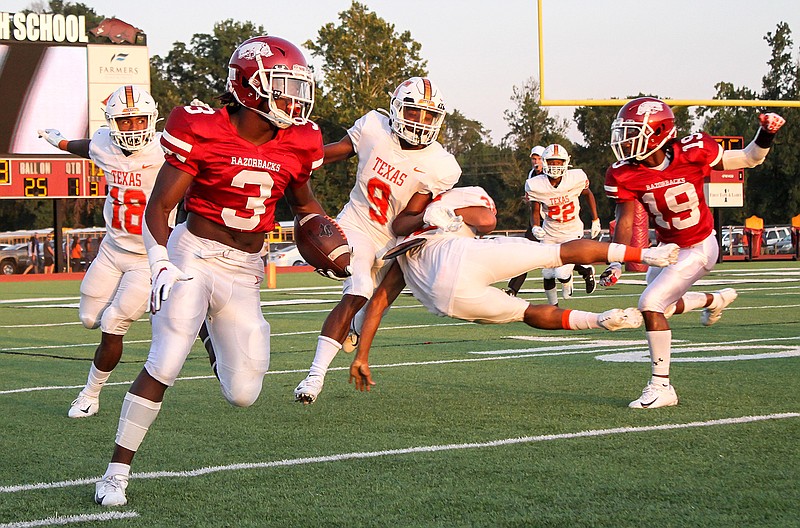 Arkansas High running back Torie Blair (3) sidesteps Texas High defenders on a kickoff return after the Tigers scored during early play Friday at Razorback Stadium. 