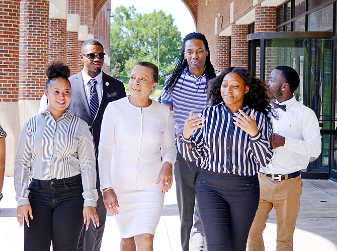 Lincoln University President Jerald Jones Woolfolk, center, talks to students as they walk by Inman E. Page Library on LU's campus.