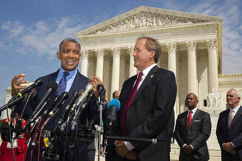 District of Columbia Attorney General Karl Racine, with Texas Attorney General Ken Paxton, right, and a bipartisan group of state attorneys general speaks to reporters in front of the U.S. Supreme Court in Washington, Monday, Sept. 9, 2019 on an antitrust investigation of big tech companies. 