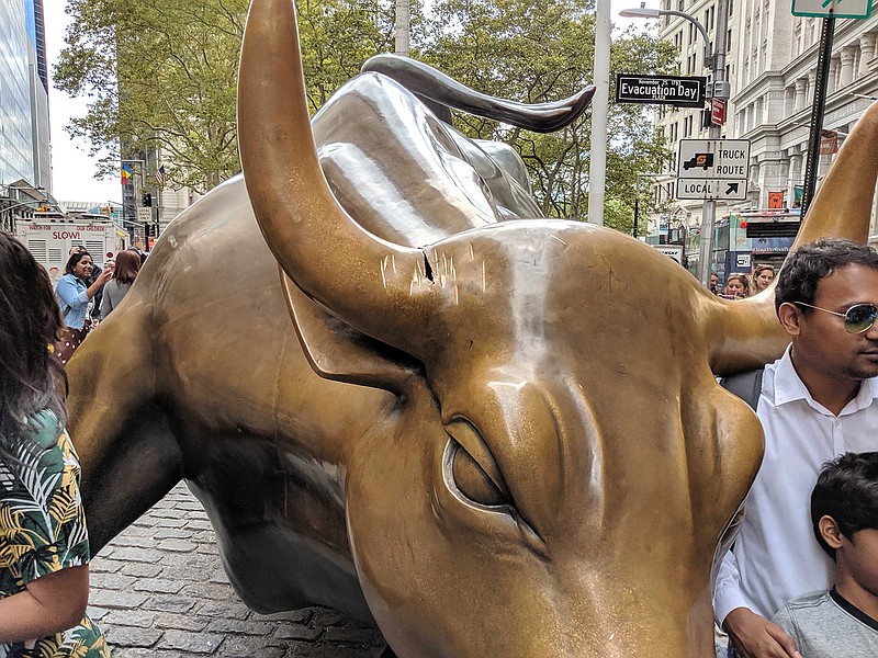 Tourists pose for photos Saturday, Sept. 7, 2019, next to the damaged Charging Bull statue on Morris Street and Broadway in Manhattan, New York. Dallas resident Tevon Varlack, 42, was charged with criminal mischief, weapons possession and disorderly conduct Saturday after he was seen repeatedly striking the statue's head with a metal object.