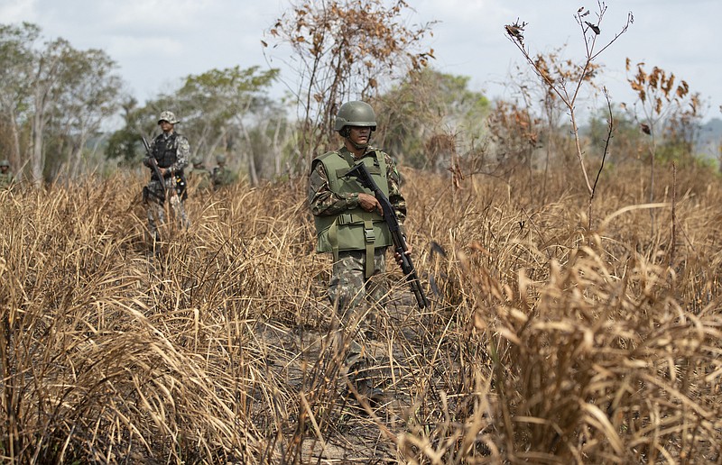 Soldiers patrol through a field that was recently burned as they search for illegal miners and loggers near Altamira, Para state, Brazil, Thursday, Sept. 5, 2019. The Brazilian Amazon saw close to 31 thousand fires in August, the highest for the month since 2010, according to Brazil's National Institute for Space Research. (AP Photo/Andre Penner)