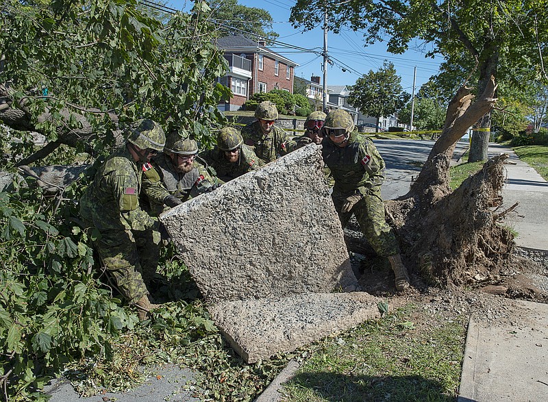 Members of the 4 Engineer Support Regiment from Camp Gagetown assist in the cleanup in Halifax, Nova Scotia on Monday, Sept. 9, 2019. Hurricane Dorian brought wind, rain and heavy seas that knocked out power across the region. (Andrew Vaughan/The Canadian Press via AP)