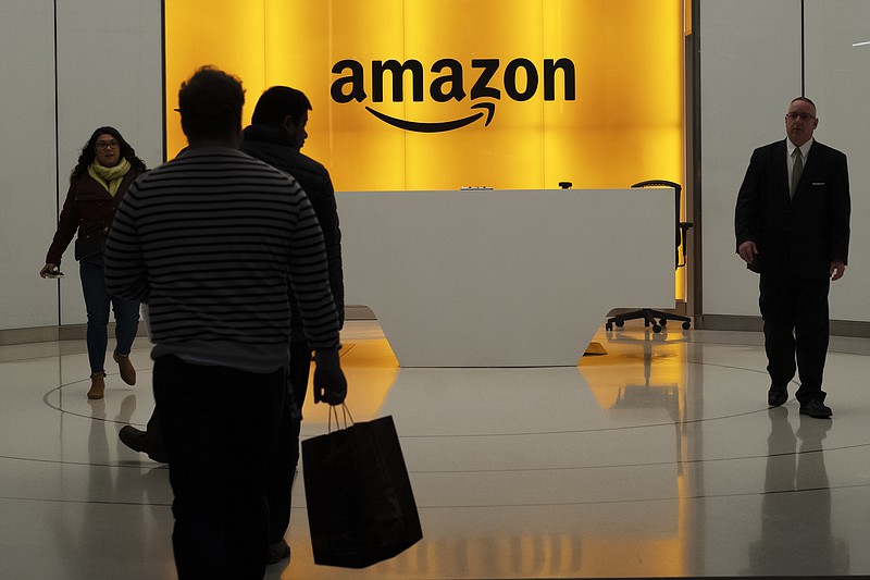 FILE - In this Feb. 14, 2019, file photo people walk into the lobby for Amazon offices in New York. The online shopping giant is holding job fairs across the country next week, aiming to hire more than 30,000 people by early next year, a 5% bump in its total workforce. (AP Photo/Mark Lennihan, File)