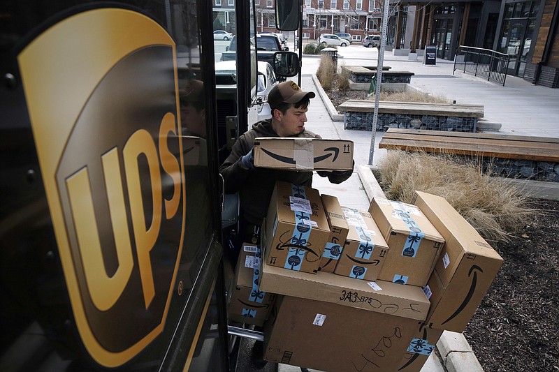 FILE- In this Dec. 19, 2018, file photo a UPS driver prepares to deliver packages. UPS said Monday, Sept. 9, 2019, that it expects to hire about 100,000 seasonal workers and pay them more to handle the avalanche of packages shipped between Thanksgiving and Christmas. (AP Photo/Patrick Semansky, File)