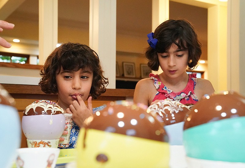 Kiran Thammon, 7, and Divya, 9, dipped balloons in melted chocolate and added sprinkles to make chocolate bowls from a new book, "Kitchen Science Lab for Kids." (Glen Stubbe/Minneapolis Star Tribune/TNS) 