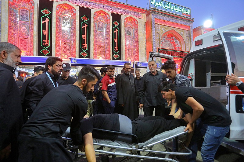 People evacuate an injured man after a walkway collapsed and set off a stampede as thousands of Shiite Muslims marked one of the most solemn holy days of the year in the holy city of Karbala, Iraq, Tuesday, Sept. 10, 2019. Officials say at least 31 people have died and around 100 others were injured in the chaos Tuesday, which occurred toward the end of the Ashoura procession, causing panic and a stampede, according to two officials. (AP Photo/Anmar Khalil)