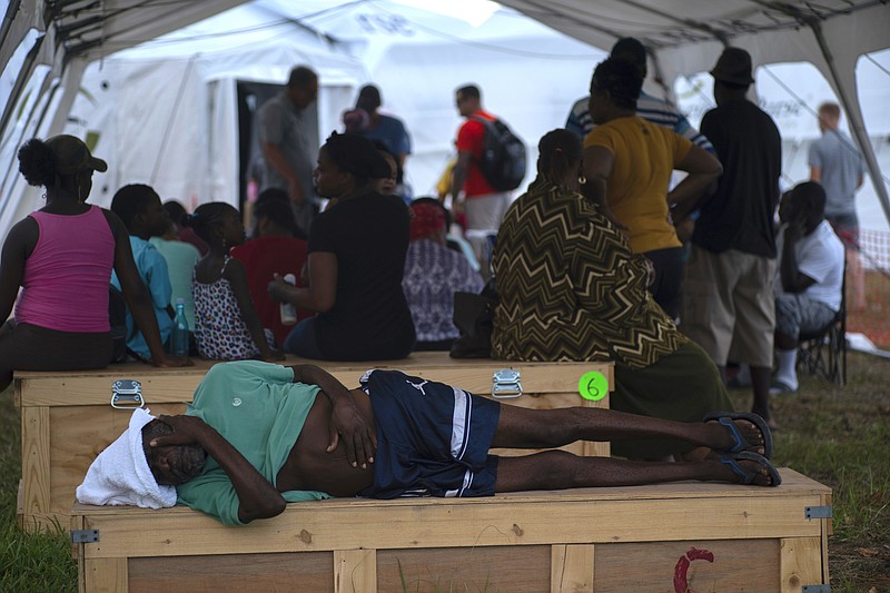 An elderly man waits to be attended at a tent-hospital set up by Samaritan's Purse in the aftermath of Hurricane Dorian in Freeport, Bahamas, Tuesday, Sept. 10, 2019. Thousands of hurricane survivors are facing the prospect of starting their lives over but with little idea of how or where to even begin. (AP Photo/Ramon Espinosa)