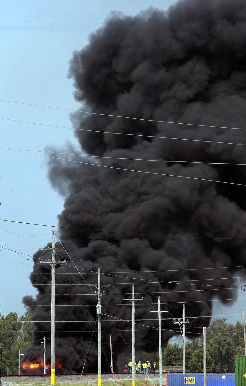 Union Pacific workers and firefighters stage at the scene of a tanker fire from a derailed train near downtown Dupo, Ill. on Tuesday, Sept. 10. 2019. Black smoke coming from the derailment scene can be seen for miles and caused the evacuation of schools in the town, authorities said. (Robert Cohen/St. Louis Post-Dispatch via AP)