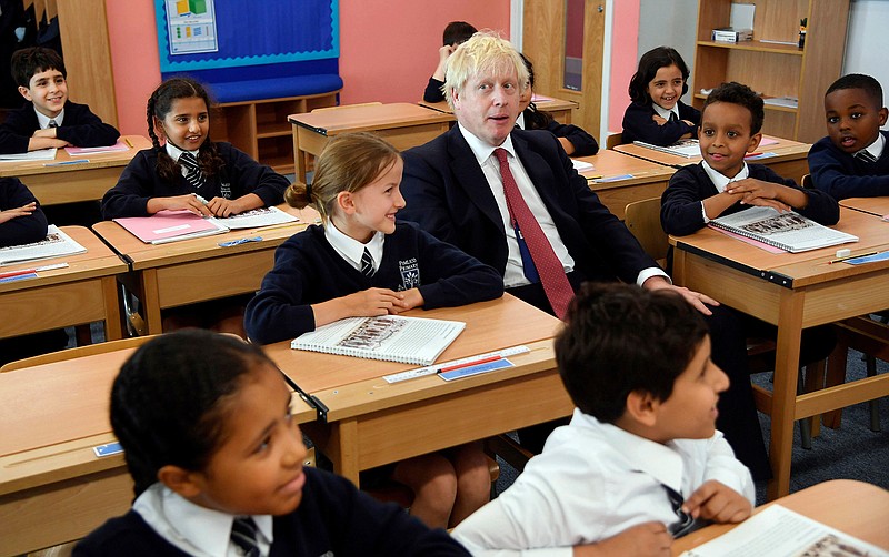 Britain's Prime Minister Boris Johnson, center, visits Pimlico Primary school in London, Tuesday July 10, 2018, to meet staff and students. (Toby Melville/Pool via AP)