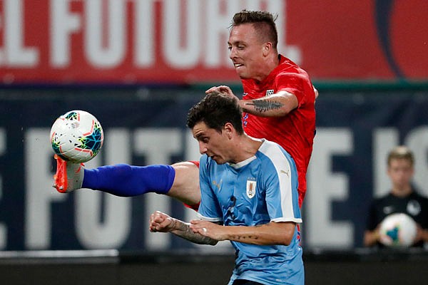 Corey Baird of the U.S. goes for the ball as Uruguay's Jose Gimenez defends during the second half of Tuesday night's match at Busch Stadium.