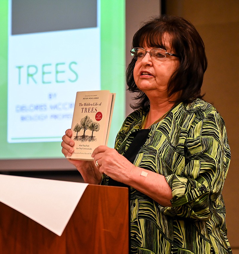 Delores McCright, retired Texarkana College biology professor, holds "The Hidden Life of Trees" by Peter Wohlleben on Tuesday at the meeting of Friends United for a Safe Environment at the Texarkana Library in Texarkana, Texas. McCright discussed Wohlleben's theories that trees in a forest communicate and share nutrients.