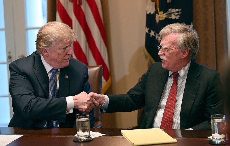 In this April 9, 2018 file photo, President Donald Trump, left, shakes hands with national security adviser John Bolton in the Cabinet Room of the White House in Washington at the start of a meeting with military leaders.  Trump has fired national security adviser John Bolton. Trump tweeted Tuesday that he told Bolton Monday night that his services were no longer needed at the White House.  (AP Photo/Susan Walsh)