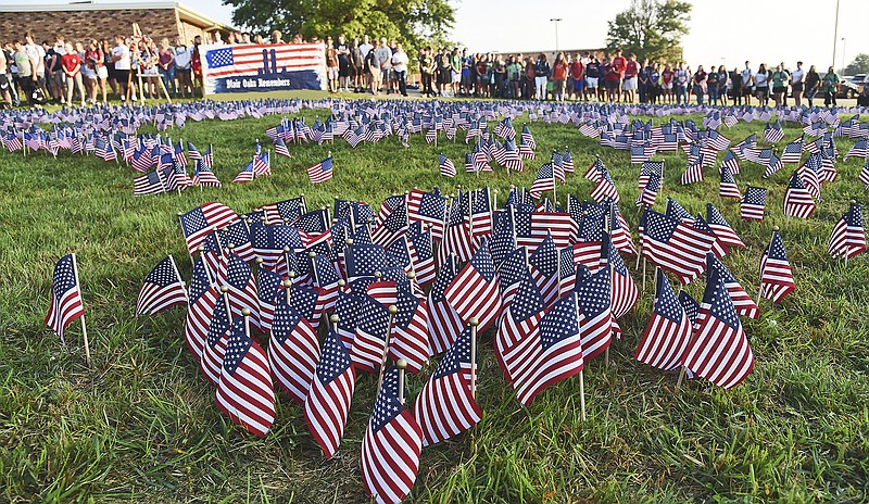 The early morning sun continues to cast its glow on Blair Oaks students and staff as they form a large ring to encircle the nearly 3,000 flags placed in the ground in front of the high school. As in previous years, before the start of classes, Blair Oaks High School students hosted a remembrance ceremony to recall the Sept. 11, 2001, attacks that took the lives of nearly 3,000 people, in their effort to make sure those events and lost lives are not forgotten. In addition to the flags, a wreath to recognize the loss of first responders was placed on a stand next to a large sign featuring a silhouette against the backdrop of an American flag with the words "Blair Oaks Remembers" painted on it.