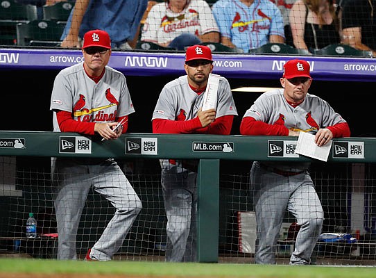(From left) Cardinals manager Mike Shildt, bench coach Oliver Marmol and first base coach Stubby Clapp watch during the seventh inning of Wednesday night's game against the Rockies in Denver.