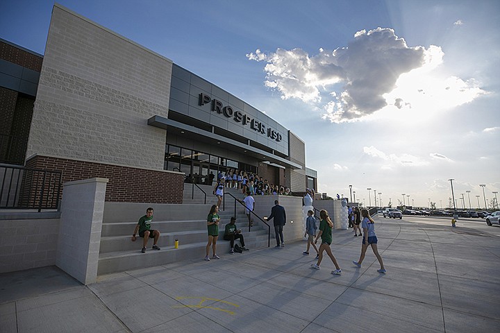 People walk to the entrance during the opening of the new Children's Health Stadium at Prosper ISD on Saturday, Aug. 17, 2019, in Prosper, Texas. Democrats are out to show they're serious about flipping Texas in 2020 by holding Thursday's presidential debate in Houston. Republicans are coming off their worst election in Texas in a generation. Fast-changing suburbs are trending more liberal, and Democrats are counting on more left-leaning voters moving in to turn the state blue. But that transformation may not arrive by 2020, and the GOP is closely watching conservative bastions like the booming Dallas suburbs. (AP Photo/Nathan Hunsinger)