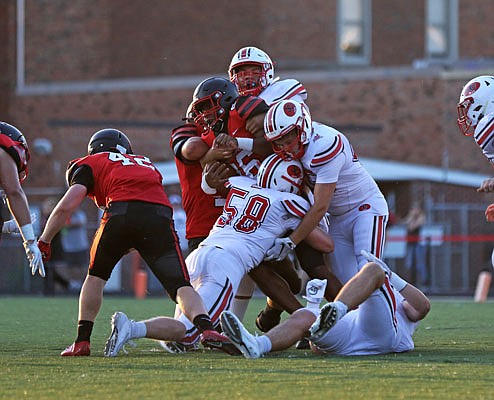 Jefferson City teammates Alex Burkhead (58), Bryant Gipe (right) and Darrion Luebbert (top) tackle Hannibal running back Damien French during last Friday night's game in Hannibal.