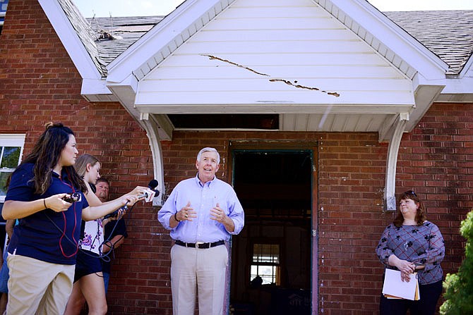 Gov. Mike parson gives a speech in front of a damaged home during a recognition ceremony along Jackson Street. The ceremony recognized Mid-Continent Steel and Wire's donation of 1 million nails to River City Habitat for Humanity.
