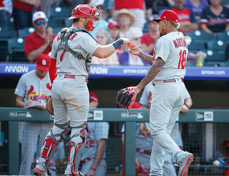 Cardinals catcher Andrew Knizner congratulates Carlos Martinez after he struck out Tony Wolters to end the eighth inning of Thursday's game in Denver.