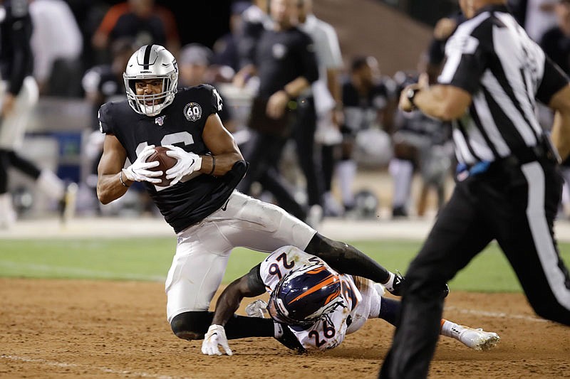 Raiders wide receiver Tyrell Williams tumbles over Broncos cornerback Isaac Yiadom after making a reception during last Monday night's game in Oakland, Calif. Sunday's Chiefs-Raiders game could be the final NFL contest ever played on a field with infield dirt.