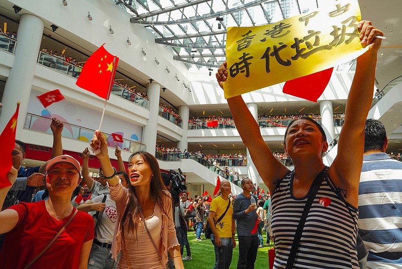 Pro-China protesters wave China national flags at a shopping mall in Hong Kong, Friday, Sept. 13, 2019. Protest-related activities are expected to continue Friday, when Chinese celebrate the Mid-Autumn Festival with lanterns and mooncakes. (AP Photo/Vincent Yu)