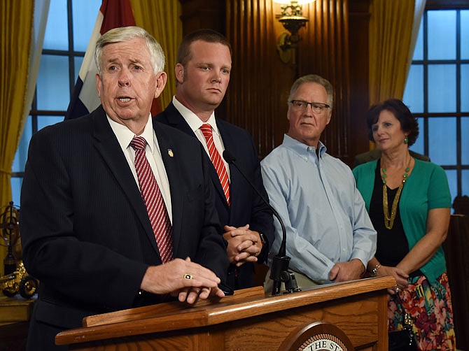 Gov. Mike Parson was joined by Scott Kehlenbrink, second from left, and Scott's parents, David and Jill Kehlenbrink, as Parson held a press conference Friday afternoon to talk about the Legislature's passage of House Bill 1, the amendment to motor vehicle sales tax allowances. 