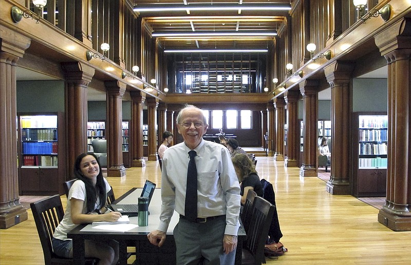 In this Aug. 28, 2019 photo, University of Vermont Professor Wolfgang Mieder poses in the school's library in Burlington, Vt., where his vast collection of books on proverbs are now housed in a new collection. The preeminent proverb scholar had been concerned about what would happen to his extensive collection on proverbs if something happened to him. (AP Photo/Lisa Rathke)