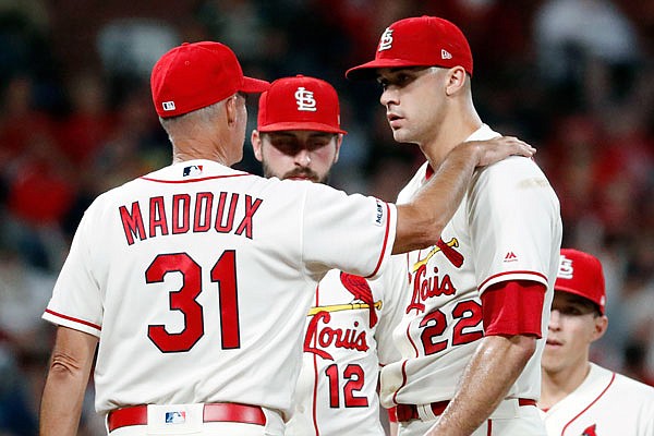 Cardinals pitching coach Mike Maddux talks with starting pitcher Jack Flaherty as shortstop Paul DeJong listens during the sixth inning of Saturday night's game against the Brewers at Busch Stadium.