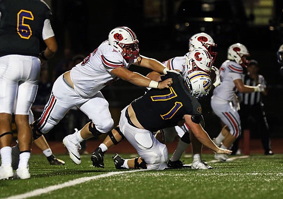 Jefferson City offensive lineman Harrison Mobley blocks Hickman's Gabe Britt as running back David Bethune scores a touchdown during Friday night's game in Columbia.